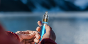 man holding aspire cyber g pen vape in blue